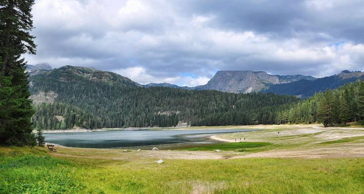 Lago alpino rodeado de bosques y montañas.