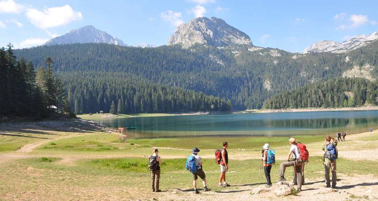 Grupo de excursionistas junto a un lago de montaña.