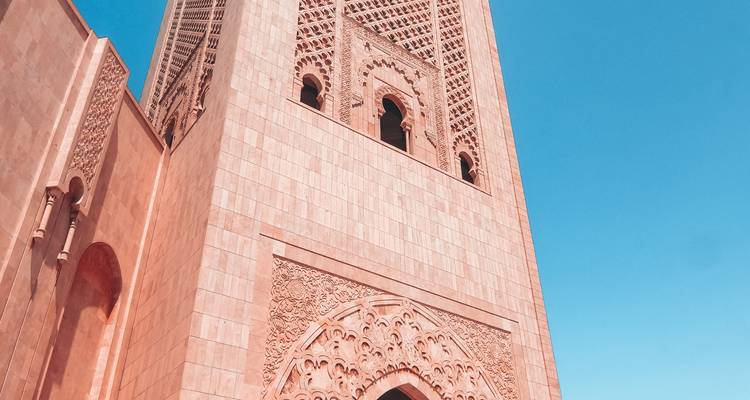 Ingewikkelde architecturale moskee minaret tegen een blauwe lucht.