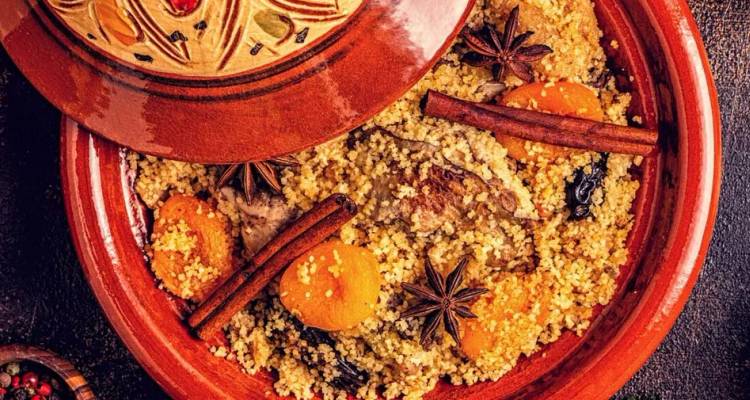 Een traditionele Marokkaanse tajine gevuld met geurige couscous, groenten en kruiden.
