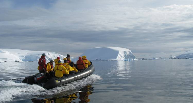 Touristes en bateau sur des eaux calmes avec des icebergs.