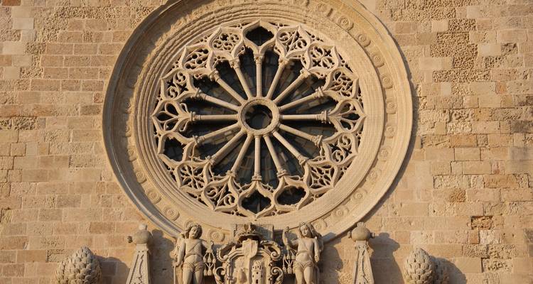 Intrincado rosetón de piedra con figuras talladas debajo.