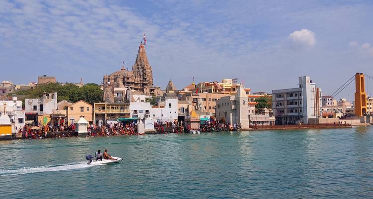 Vista de la ciudad de Dwarka con un templo y edificios junto al agua.