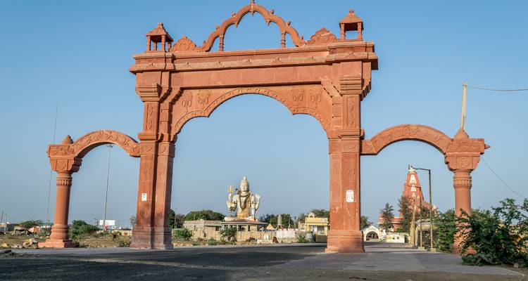 Puerta de entrada que conduce a un complejo de templos hindúes con estatuas.