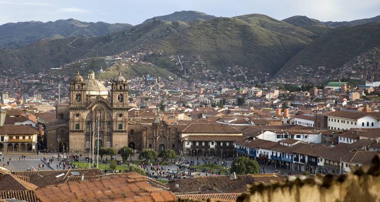Vue sur la ville de Cusco avec des bâtiments historiques remarquables et des collines.