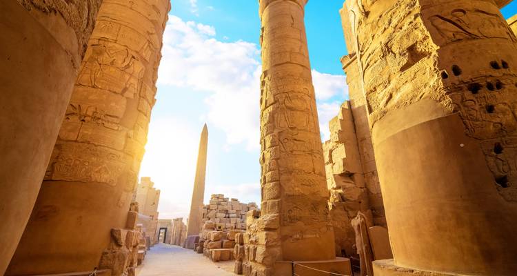 Ruinas de templo antiguo con pilares altos y obeliscos.