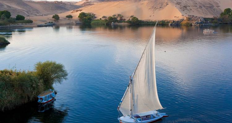 Veleros en el río Nilo con orillas arenosas.