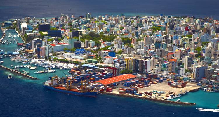 Vue aérienne de Malé avec un développement urbain dense entouré par la mer.