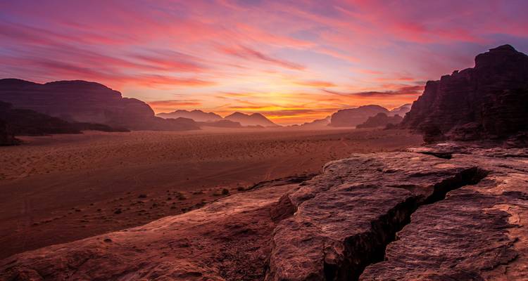 Coucher de soleil vibrant sur le paysage dramatique du Wadi Rum.