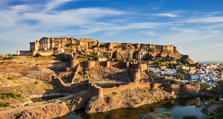 Fuerte Mehrangarh encaramado en una colina con vistas a la ciudad bajo un cielo azul claro.