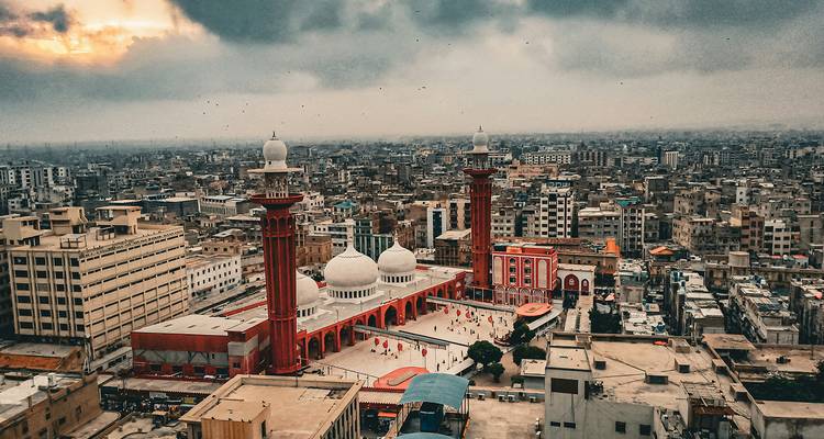Vue aérienne d'une mosquée avec un paysage urbain et un coucher de soleil.