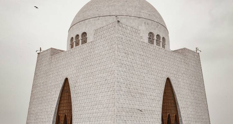 Mausolée à l'architecture unique sous un ciel nuageux.