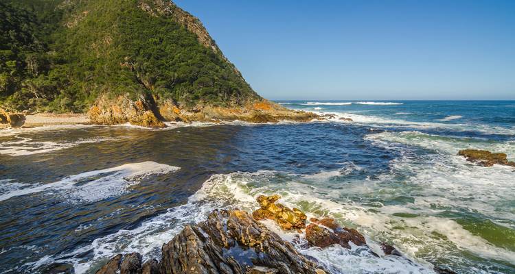Vista de una costa rocosa con olas rompiendo en la orilla.