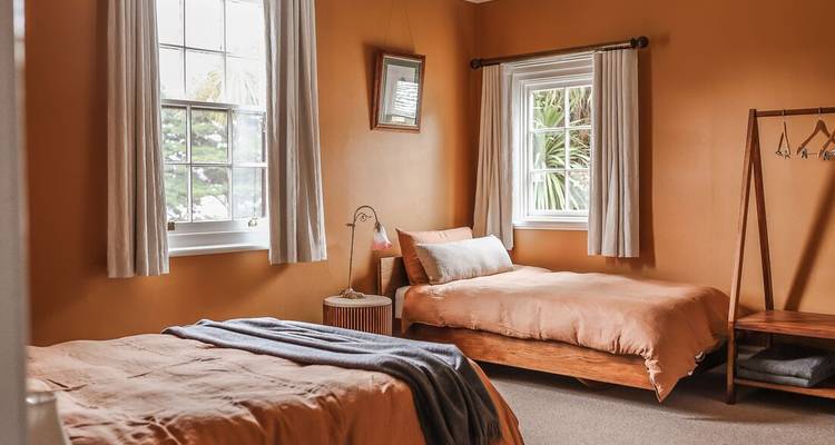 Slaapkamer met twee eenpersoonsbedden en een warm kleurenschema.