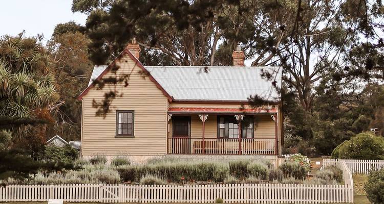 Een charmant huis op het platteland met een houten hek en tuin.