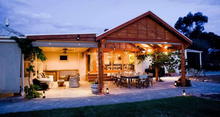 Une aire de repas extérieure dans une maison chaleureuse et bien éclairée le soir.