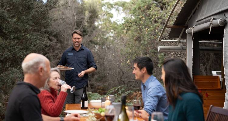 Un groupe de personnes savourant un repas en plein air dans un cadre de jardin.