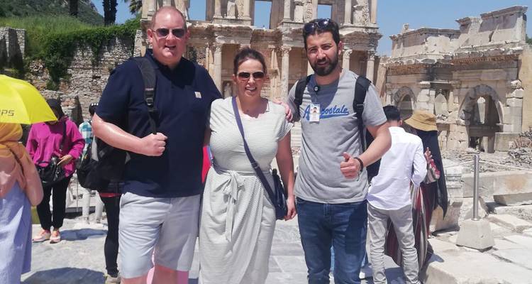 Turistas posando frente a ruinas antiguas.