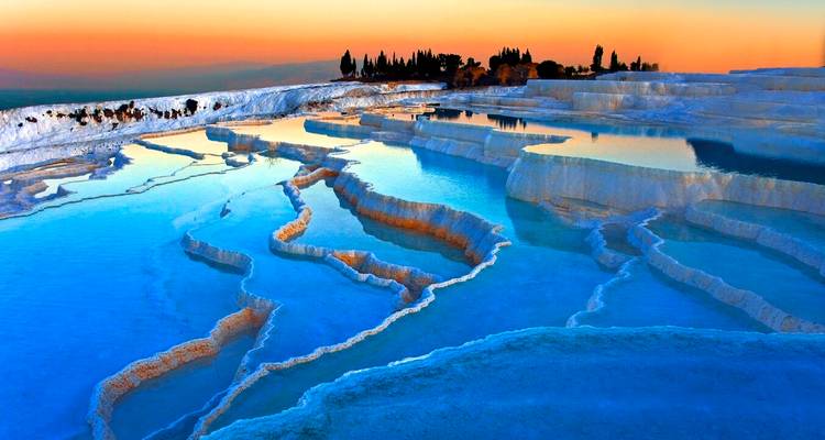 Prachtige terrasachtige warmwaterbronnen van Pamukkale bij zonsondergang.
