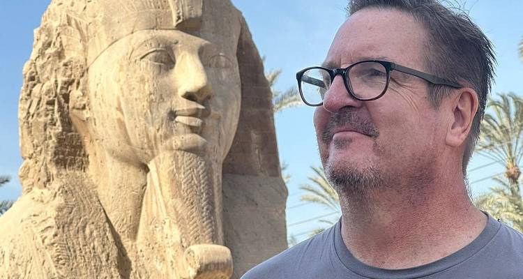 Toerist die interacteert met een Sfinxsculptuur.