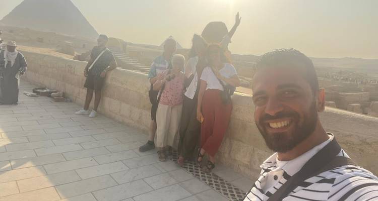 Groep toeristen met piramides op de achtergrond.