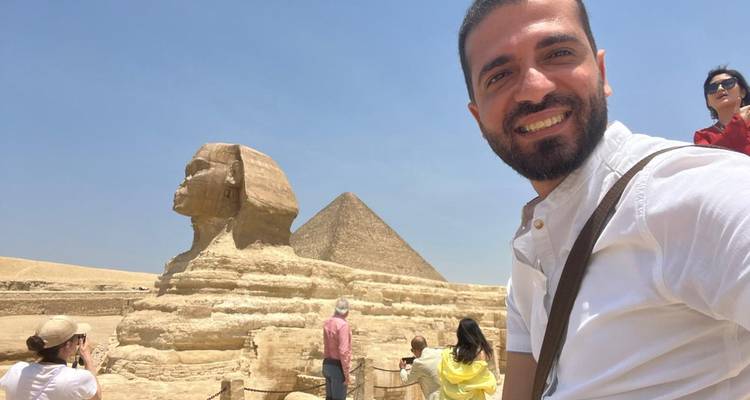 Toerist glimlachend met de Sfinx en piramide in beeld.