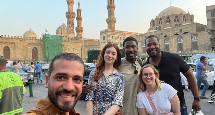 Groep mensen die glimlachen voor historische gebouwen en moskeeën.