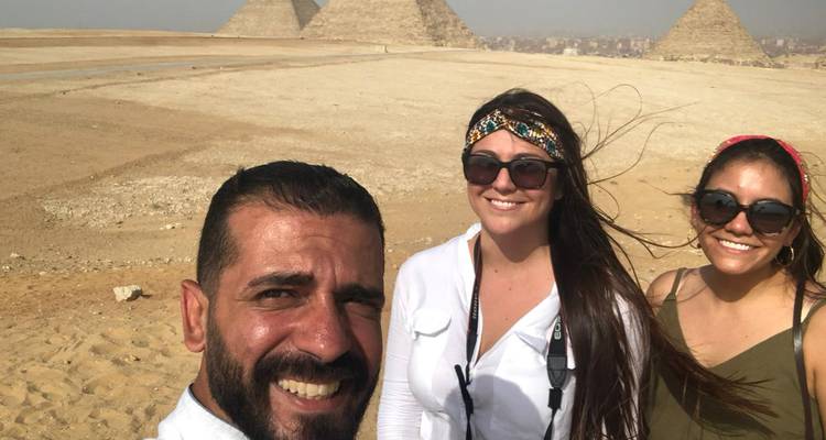 Selfie van drie mensen met piramides op de achtergrond.