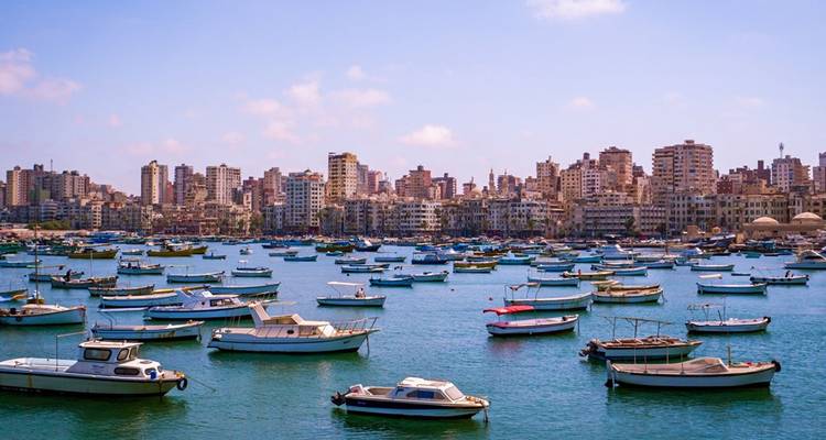 Stadshorizon met talrijke boten op de voorgrond.