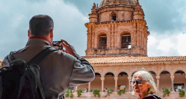 Twee toeristen die foto's maken van een oude structuur met een koepel.