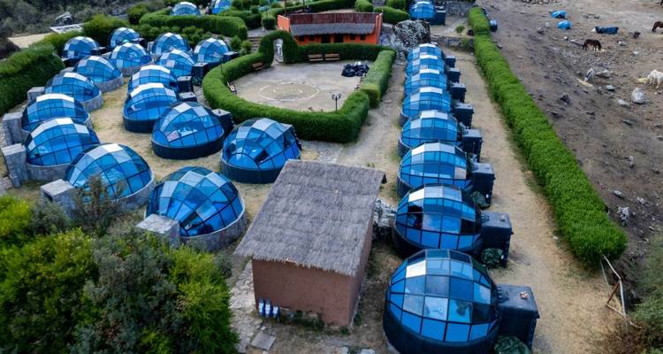 Luchtfoto van een camping met koepelvormige hutten.