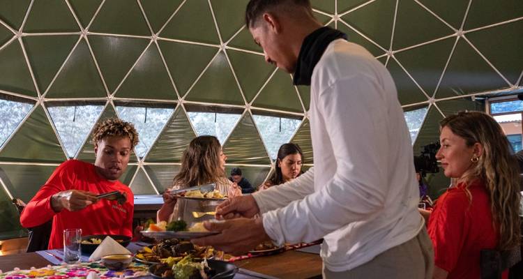 Mensen die dineren in een koepel met een geometrisch patroon.