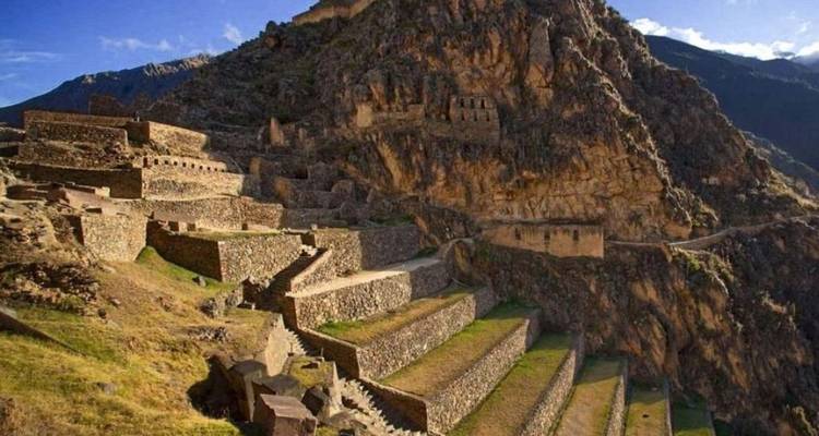 Anciennes terrasses de pierre et ruines sur un flanc de montagne.