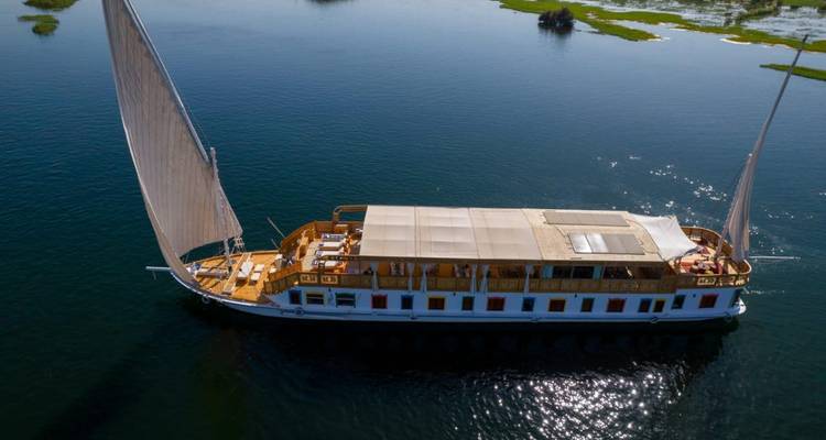 Zeilboot met opvallende zeilen op de rivier.