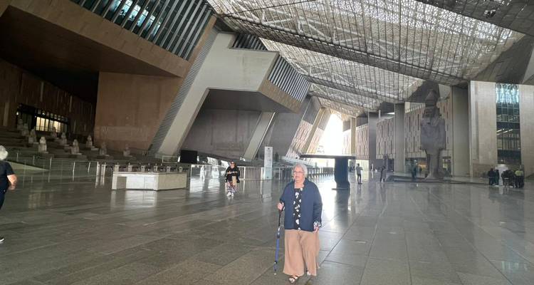 Intérieur d'un bâtiment moderne, possiblement un musée, avec un visiteur.