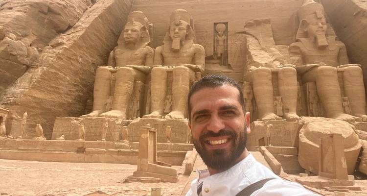 Homme posant devant les temples d'Abou Simbel.