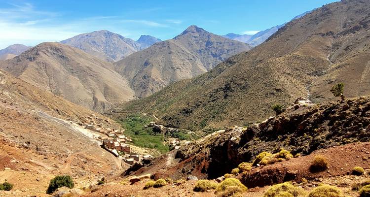 Brede blik op een bergketen met valleien en verspreide dorpen.
