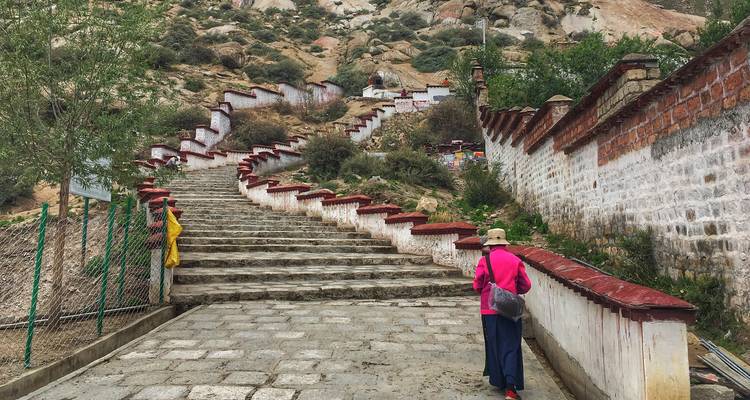Een persoon die de trappen van een klooster oploopt.
