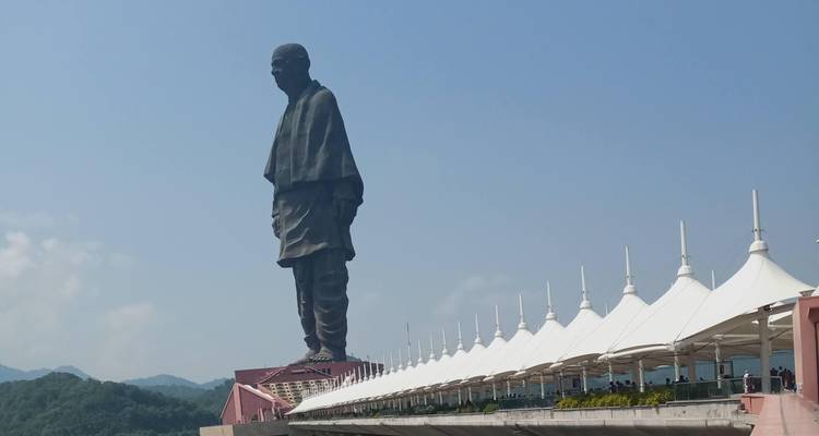 Une grande statue face à une série de tentes blanches.