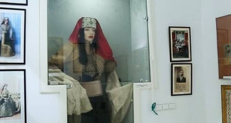 Exposition de musée avec mannequin en vêtements traditionnels.