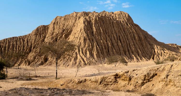 Paisaje árido de colinas erosionadas bajo un cielo azul despejado.