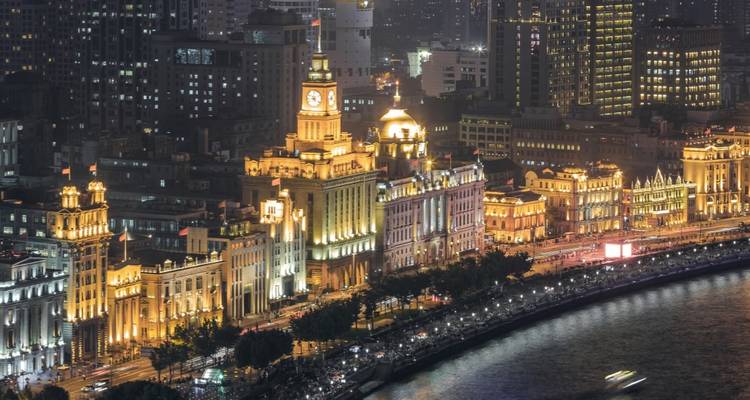 Vue nocturne de bâtiments historiques le long d'une berge.