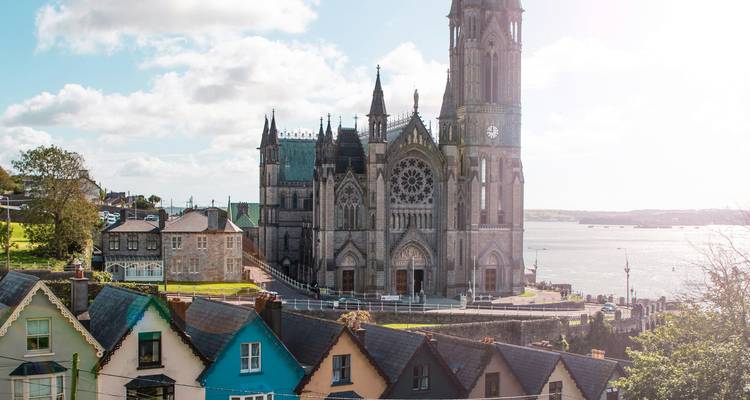 Catedral gótica con vista a un pueblo costero con casas coloridas.
