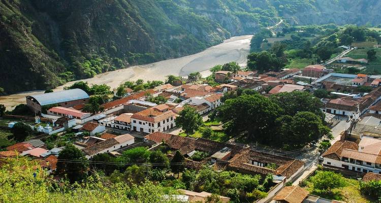 Vue aérienne d'une petite ville nichée dans une vallée près d'une rivière.
