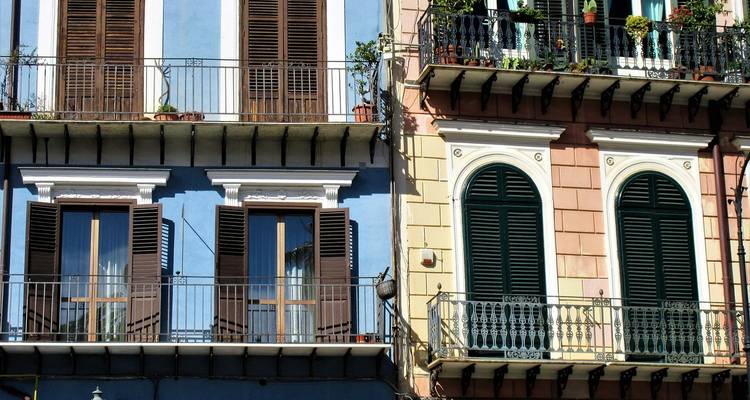 Kleurrijke appartementgevels met balkons in een stedelijke omgeving.