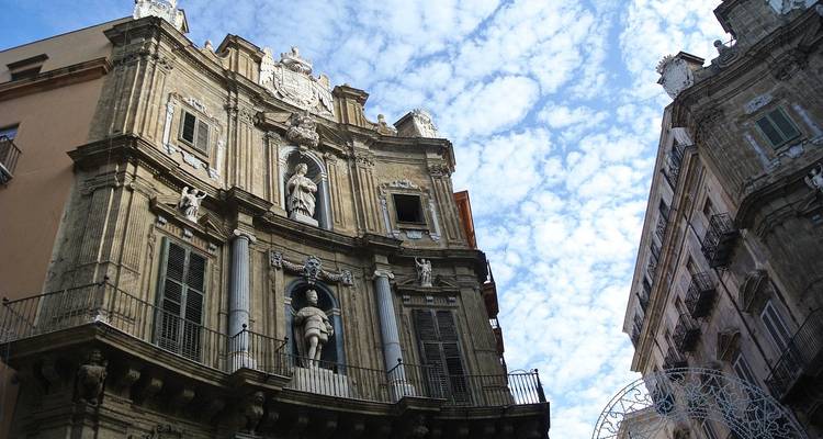 Historische architectuur met ingewikkelde gevels tegen een blauwe hemel.
