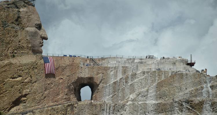 Partially completed sculpture of a large rock structure with an American flag.