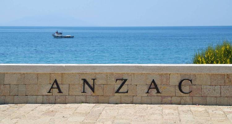 ANZAC Cove gedenkteken aan zee met een boot in de verte.