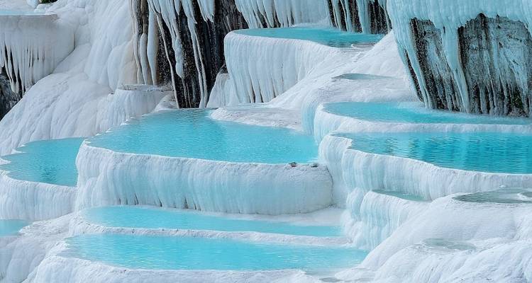 Natuurlijke terrasvormige thermale zwembaden met turkoois water.