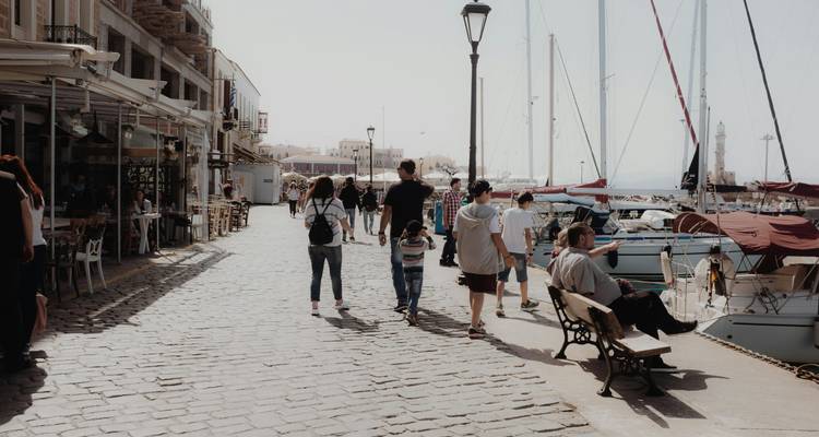 Mensen die langs een haven lopen met boten aangemeerd aan de zijkant.